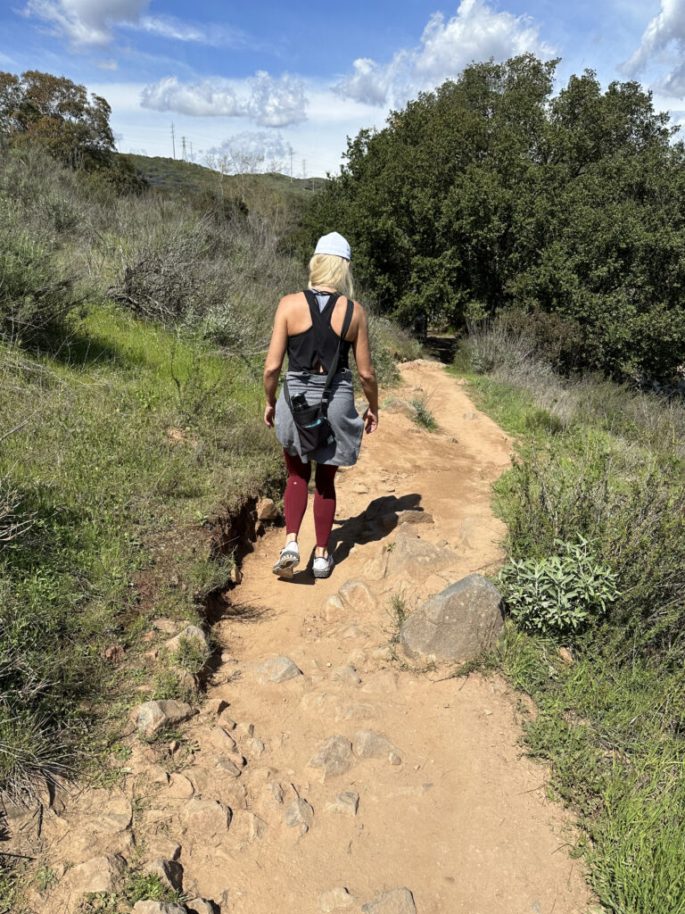 Kristi Jones walking down a narrow path, surrounded by nature

The Kristi Jones Podcast- How Hiking, Getting Lost, and Encountering Rattlesnakes Helps Me Live Life to the Fullest