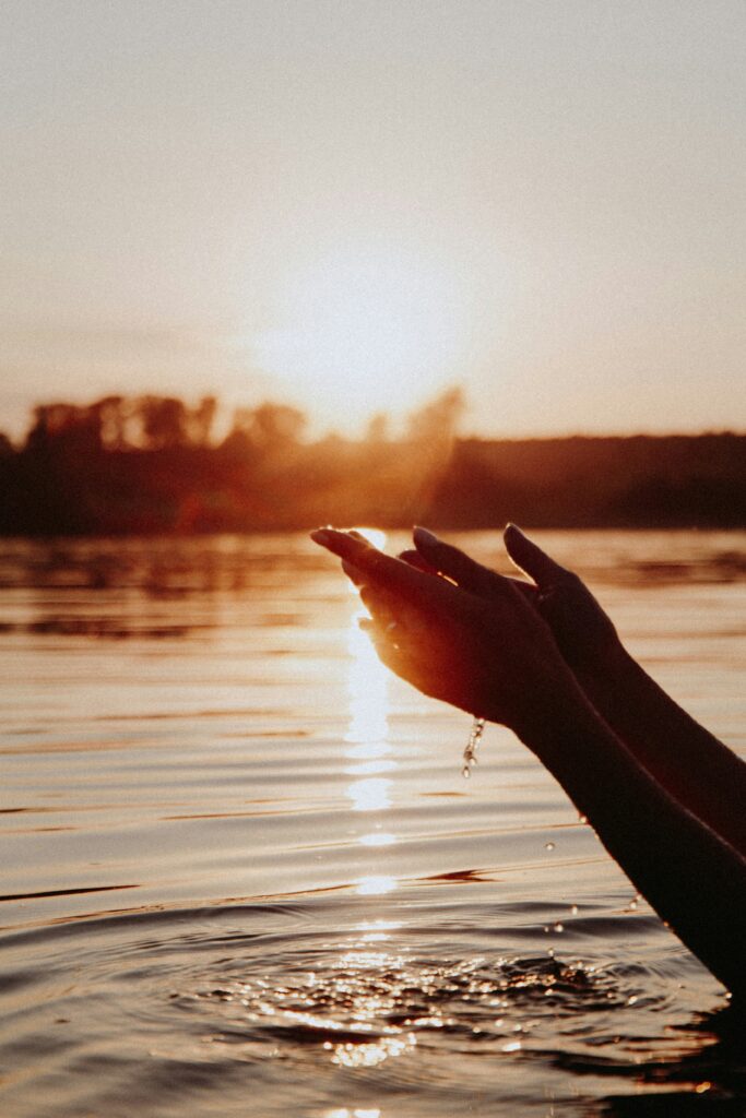 Woman's arms raised towards the sky  emerging from water at sunset, capturing a moment of blissful serenity

Kristi Jones podcast  Steady in the Storm 1