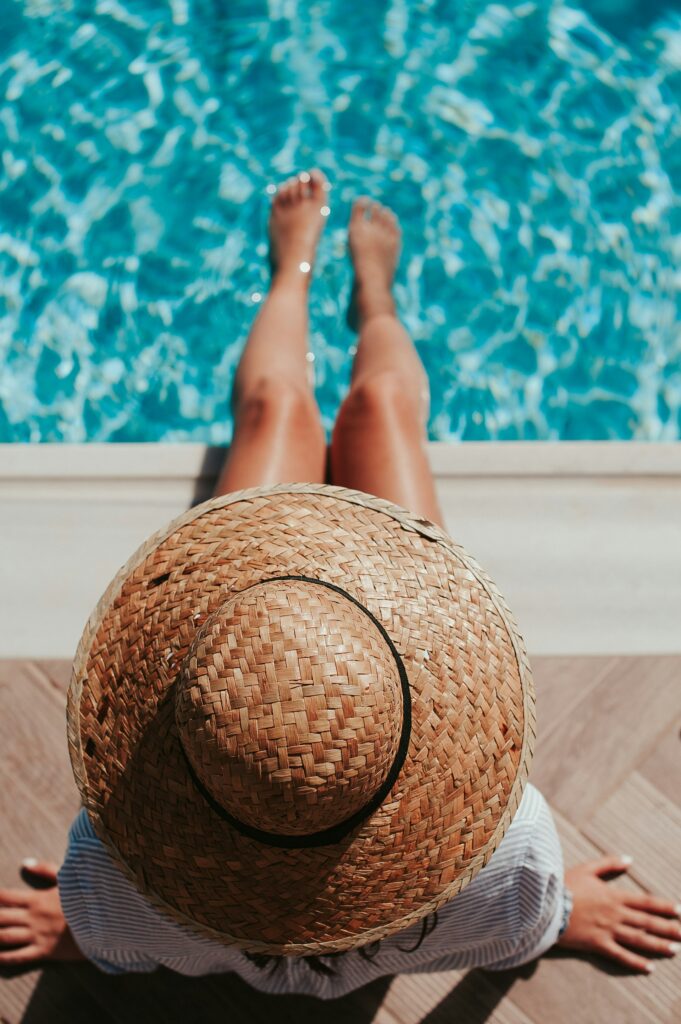 Woman wearing a summer hat and lounging by the pool with her toes dipped in the water

The Kristi Jones Podcast: Rest, Play, and Work This Summer

